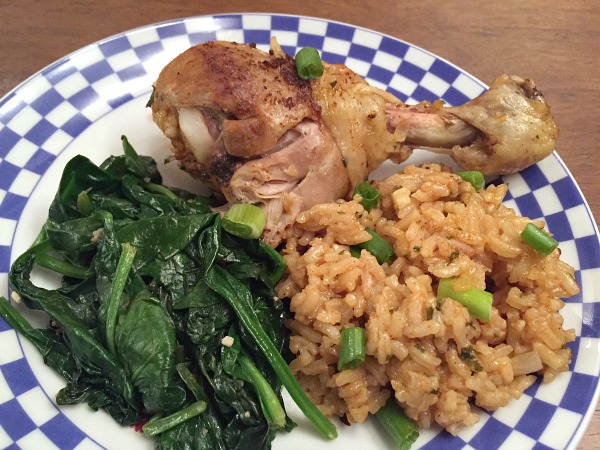 drumstick, rice, and spinach on a plate