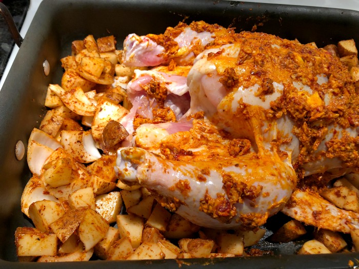 seasoned chicken and potatoes in pan