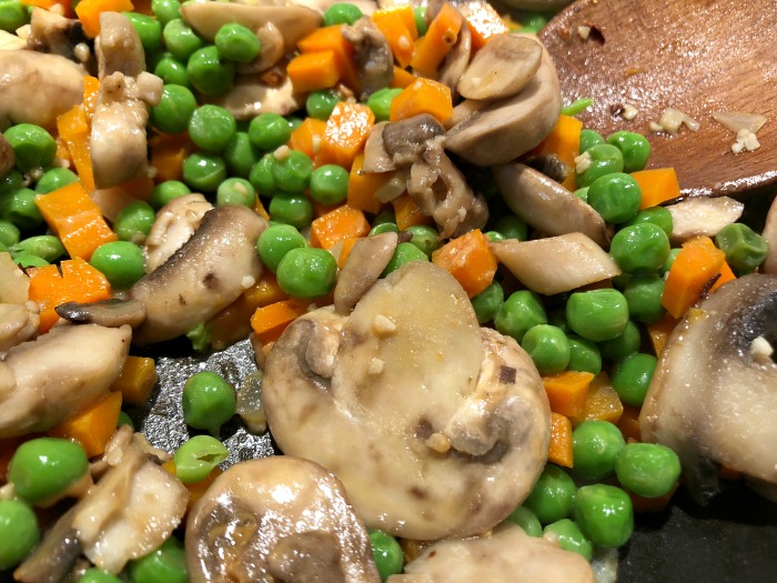 mushrooms, carrots, and peas in pan