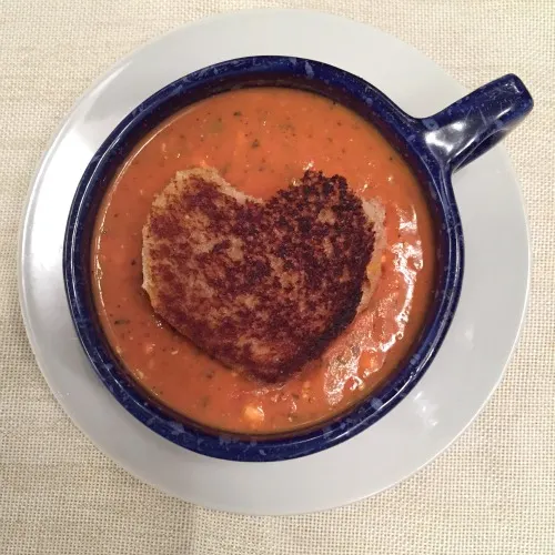 Tomato soup in a mug with grilled cheese