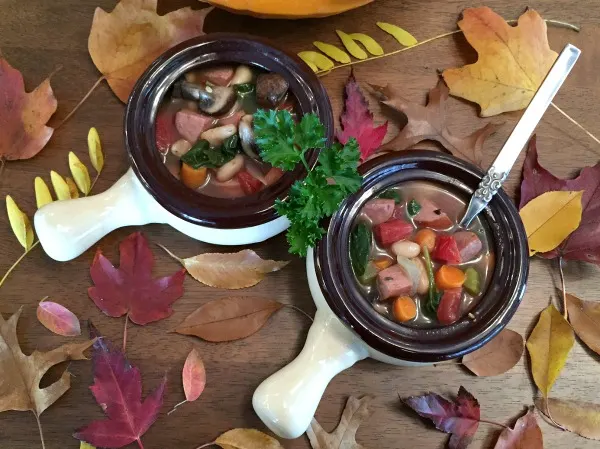 two bowls of sausage and spinach soup