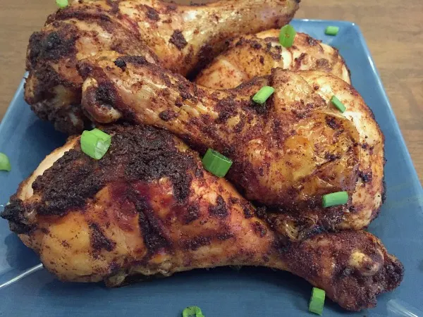 baked dry rub chicken drumsticks on a blue plate