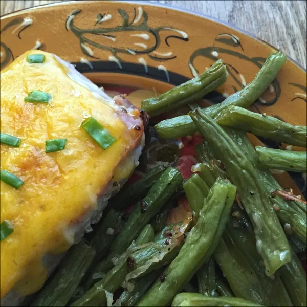 This sheet pan cheddar Parmesan pork chops & green beans recipe is naturally gluten free -- and, it's full of garlicky salty comfort food deliciousness. The chops stay nice and juicy in this one pan 45 minute weeknight dinner recipe, while the salty tang of the cheddar & Parmesan provides the perfect counterpoint.