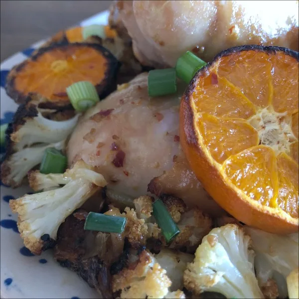 plate of chicken drumsticks with clementines and cauliflower