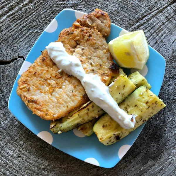How about an easy broiled pork chops and zucchini recipe that is naturally low carb and gluten free? This flavorful 30 minute weeknight dinner creates its own built-in side -- making it an affordable dinner option for four. The Greek yogurt sauce here really brings out the flavor in both the zucchini and the chops, too! | MashupMom.com