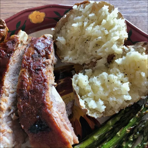 ribs, baked potato, and asparagus