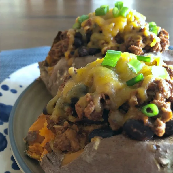 These flavorful turkey taco stuffed sweet potatoes are super easy to make, and naturally gluten free. Give this easy turkey tacos recipe a try on your next Taco Tuesday! Top the turkey taco sweet potatoes with a little shredded cheese + your own favorite taco toppings. 