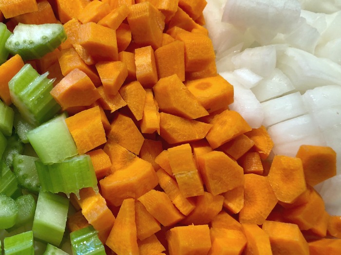 a cutting board of chopped celery, carrots, and onions