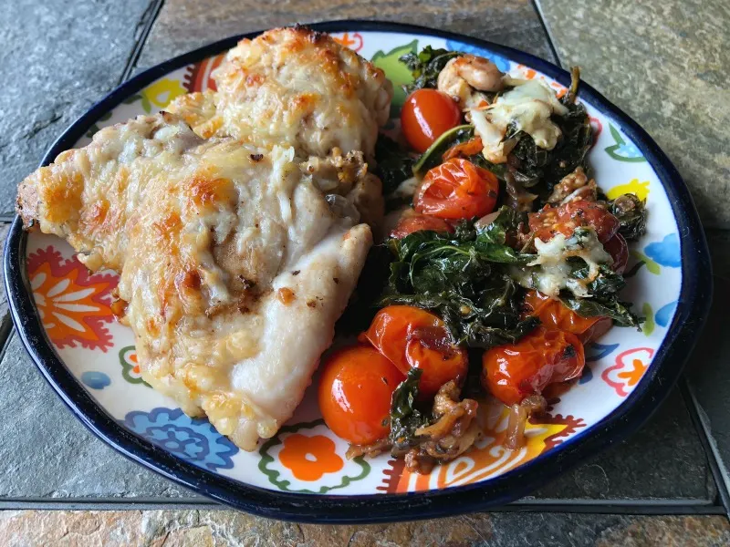 This naturally low carb & gluten free Caprese chicken + kale skillet recipe is the perfect easy one pan dinner solution if you're doing keto. (If you're not keto, a crusty loaf of bread or baguette pairs quite nicely!) | MashupMom.com plate of caprese chicken and kale