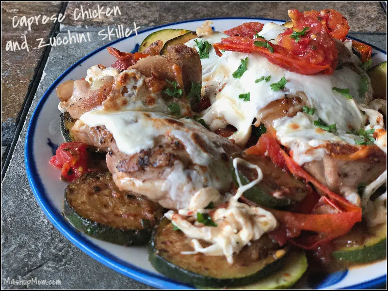 Today's Caprese Chicken and Zucchini Skillet takes advantage of seasonal fresh tomatoes and zucchini, adds chicken to the seasoned veggies for an extra pop of protein, punches things up with a little balsamic vinegar, then blankets everything in a layer of fresh (and oh-so-delicious) mozzarella... you know, just to take it over the top. This all-in-one cast iron skillet recipe is low carb, gluten free, and keto friendly. | MashupMom.com caprese chicken and zucchini skillet