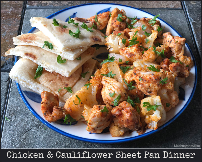 chicken & cauliflower sheet pan dinner on a plate, served with a side of naan