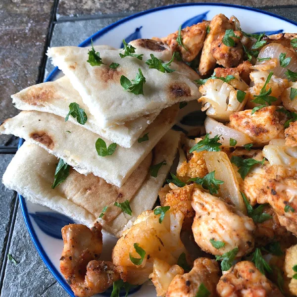 roasted chicken and cauliflower on a plate with naan