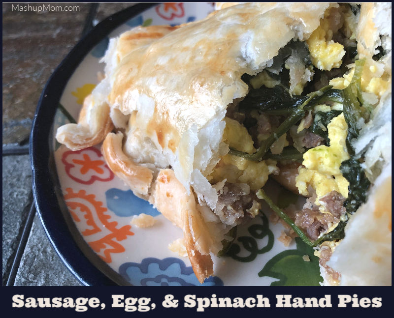 sausage, egg, & spinach hand pies cut open on a plate