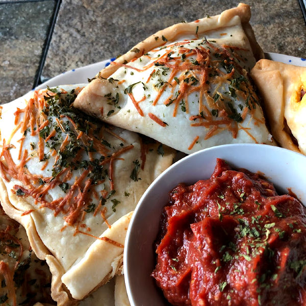 pepperoni pizza pockets on a plate with sauce