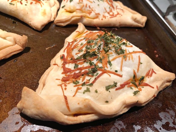 finished pizza pockets on a baking sheet