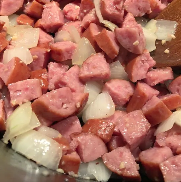 sauteed smoked sausage, onions, and garlic in a pot