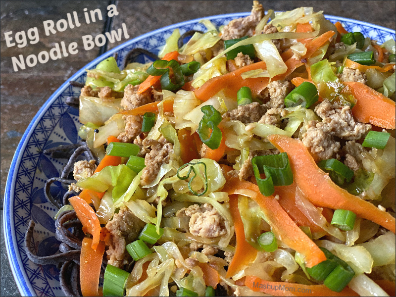 egg roll in a noodle bowl over black soybean noodles