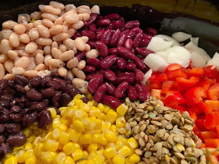 Colorful vegetarian chili ingredients in the Crock-Pot for three bean + lentil chili