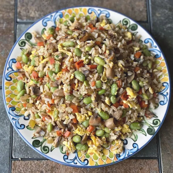 Plate of vegetable fried rice with edamame, mushrooms, carrots...