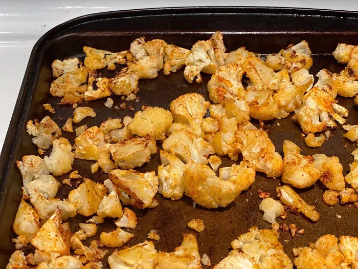 Cooked cauliflower florets on a sheet pan -- roasted with spices