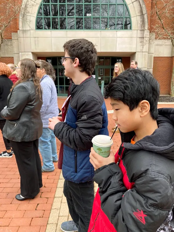 middle school kid drinking coffee on a college tour