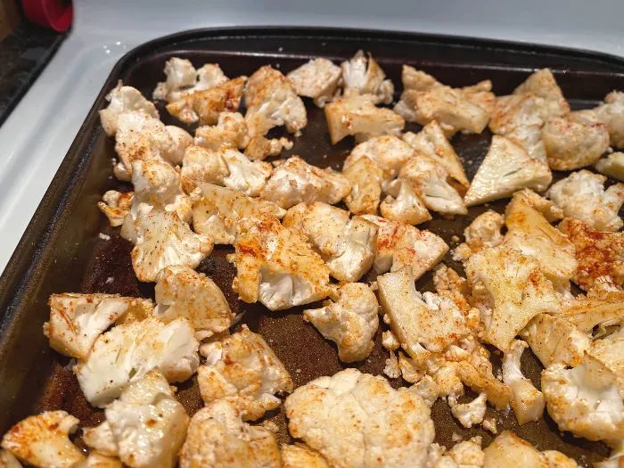 seasoned cauliflower florets on a sheet pan