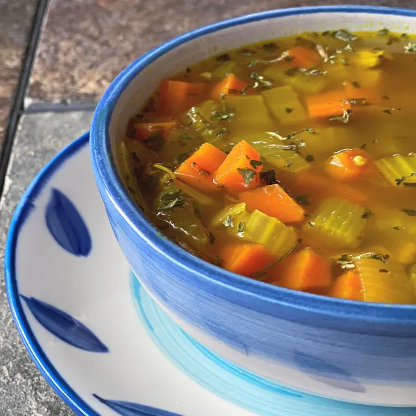 bowl of leftover chicken soup with carrots, celery, garlic, turmeric, and more!