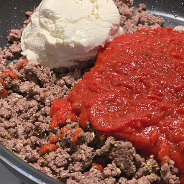 add sauce and cheese to the beef in the skillet