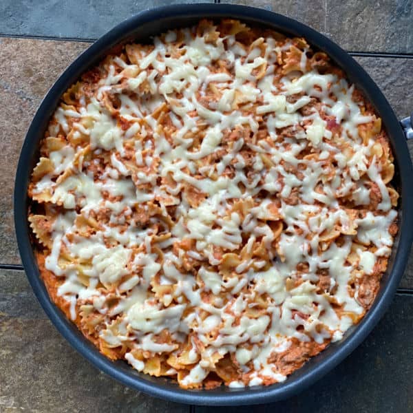 looking down on a skillet full of mozzarella topped pasta