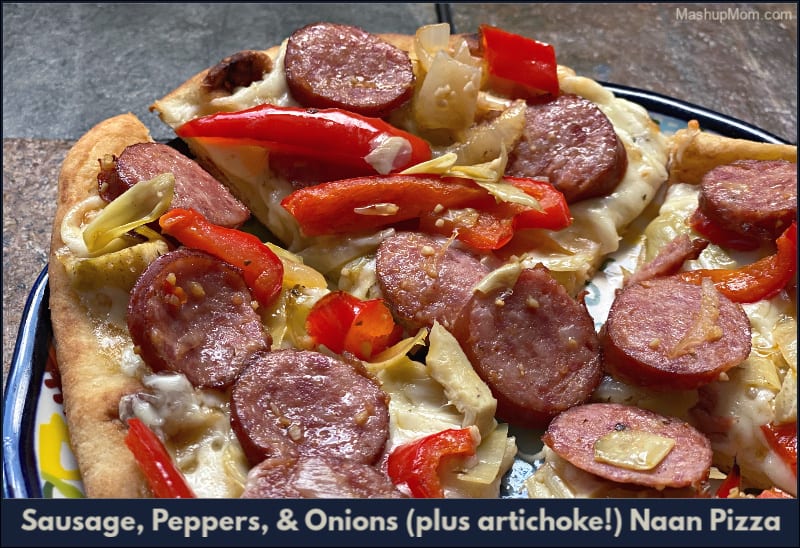 plate of naan pizza with sausage peppers onions and artichokes