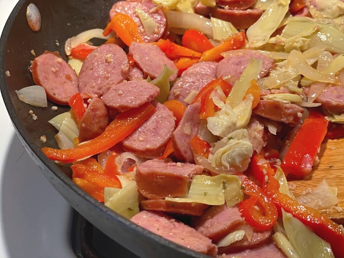 saute sausage, peppers, onions, and artichoke