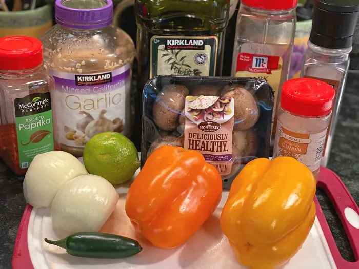 veggie fajitas ingredients -- peppers, onion, mushrooms, garlic, spices, lime juice