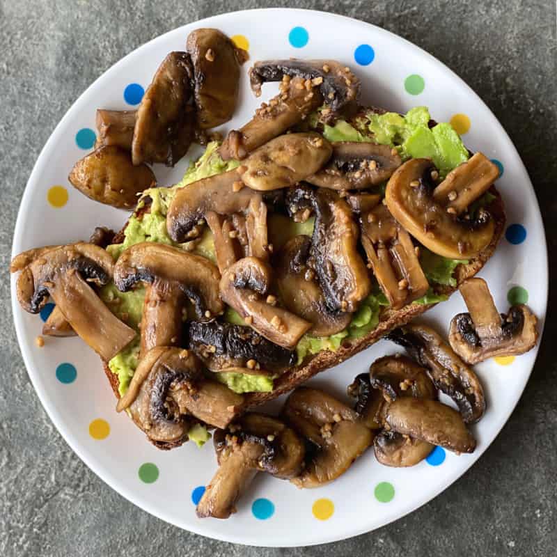 Plate of garlic soy mushrooms on avocado toast