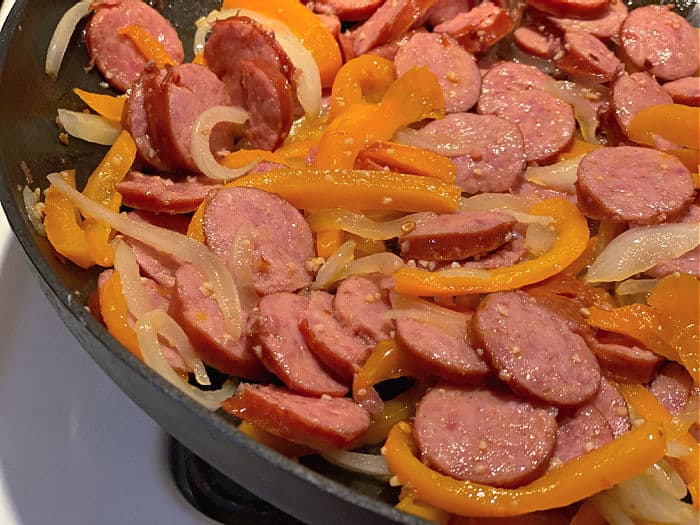 sausage, peppers, and onions in a skillet