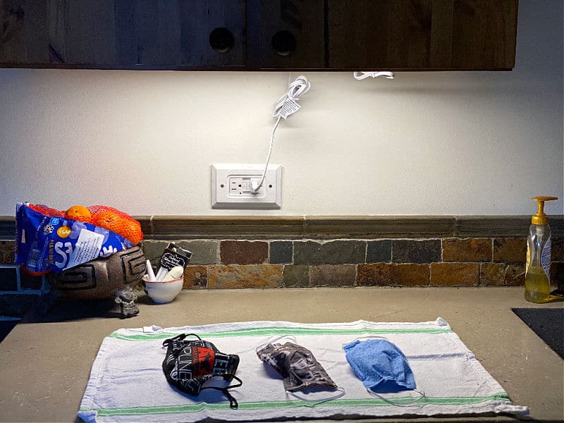 under cabinet light with masks on counter
