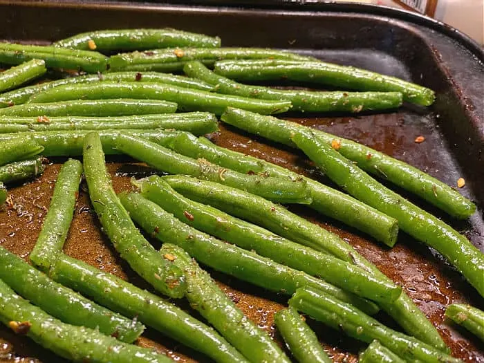season the green beans on baking sheet