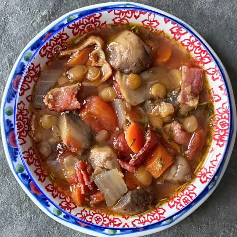 Bowl of rustic lentil mushroom soup with bacon