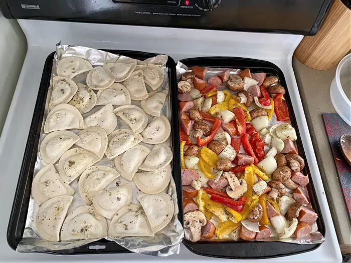 baking sheets of sausage and pierogies