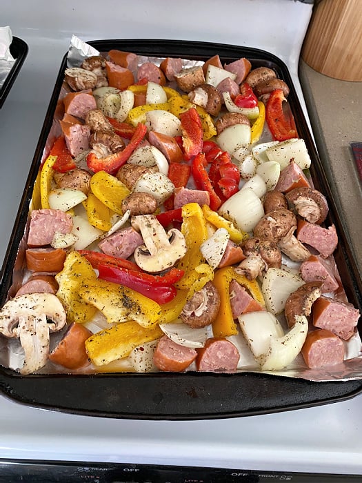 vegetables and sausage on a baking sheet