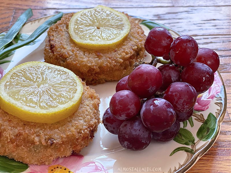 cooked crab cakes on plate with grapes