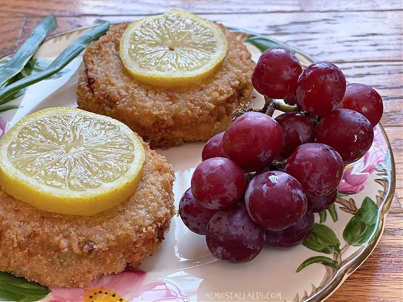 cooked crab cakes on plate with grapes