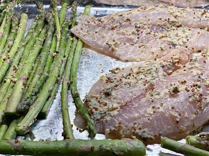 seasoned tilapia and asparagus on a sheet pan