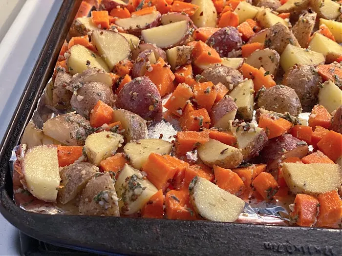 seasoned potatoes and carrots on a sheet pan