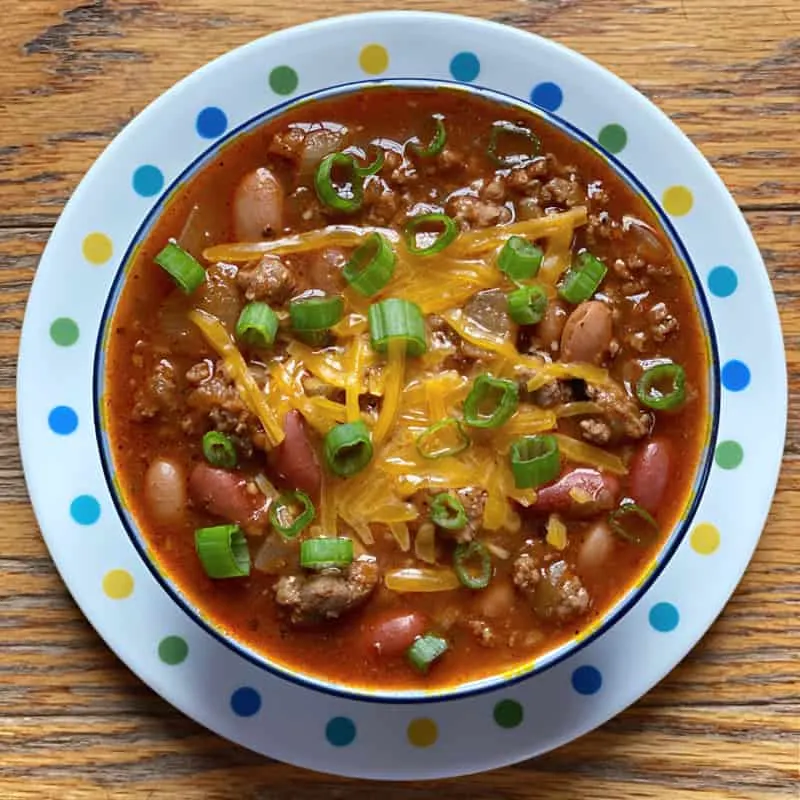 Bowl of sausage and ground beef chili with salsa verde