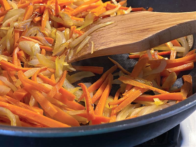 sauteed onion and carrots in a pan