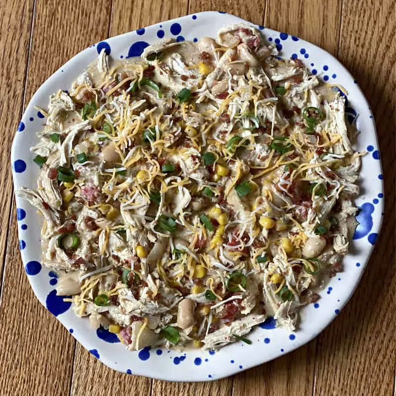 chicken chili topped with green onions, cheese, and bacon bits