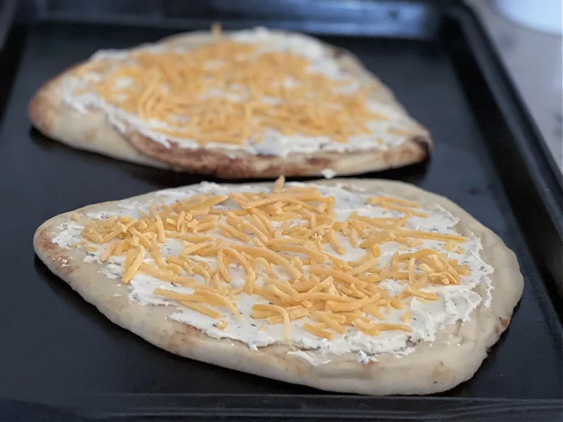 naan with cheese spread and cheddar