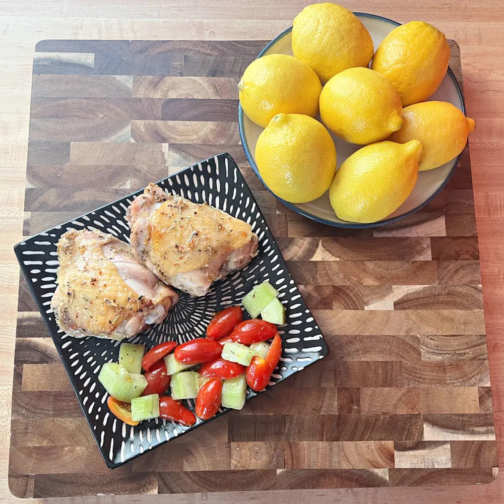 plate of chicken and bowl of lemons