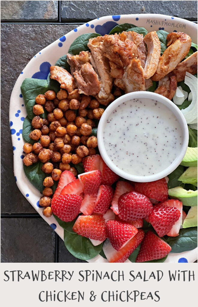 plate of spinach salad with bowl of poppyseed dressing