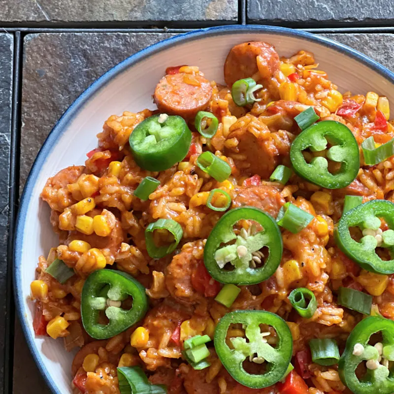 plate of cheesy smoked sausage and rice topped with jalapenos